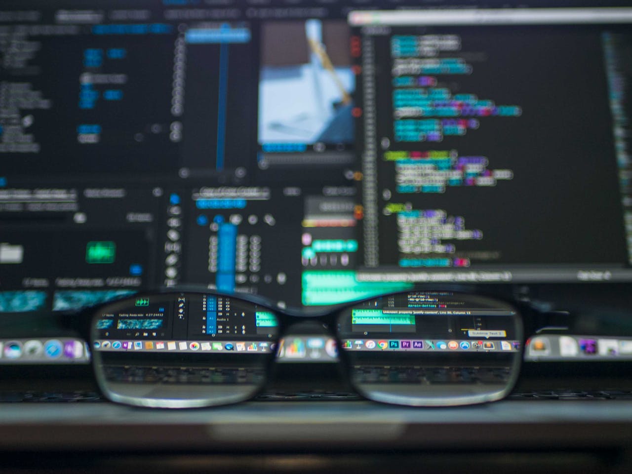 why-choose-us Eyeglasses reflecting computer code on a monitor, ideal for technology and programming themes.